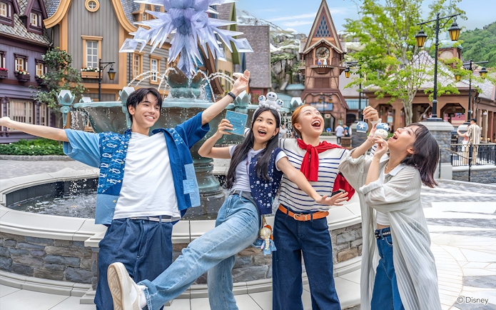 Friends enjoying at Disneyland Hong Kong near a themed fountain.