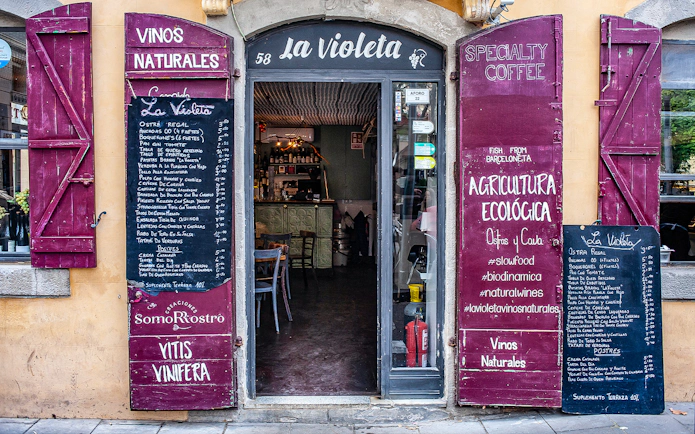 Entrance to La Violeta restaurant in La Barceloneta with menu boards displaying local dishes.