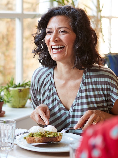 Woman enjoying brunch with friends in a bright cafe.