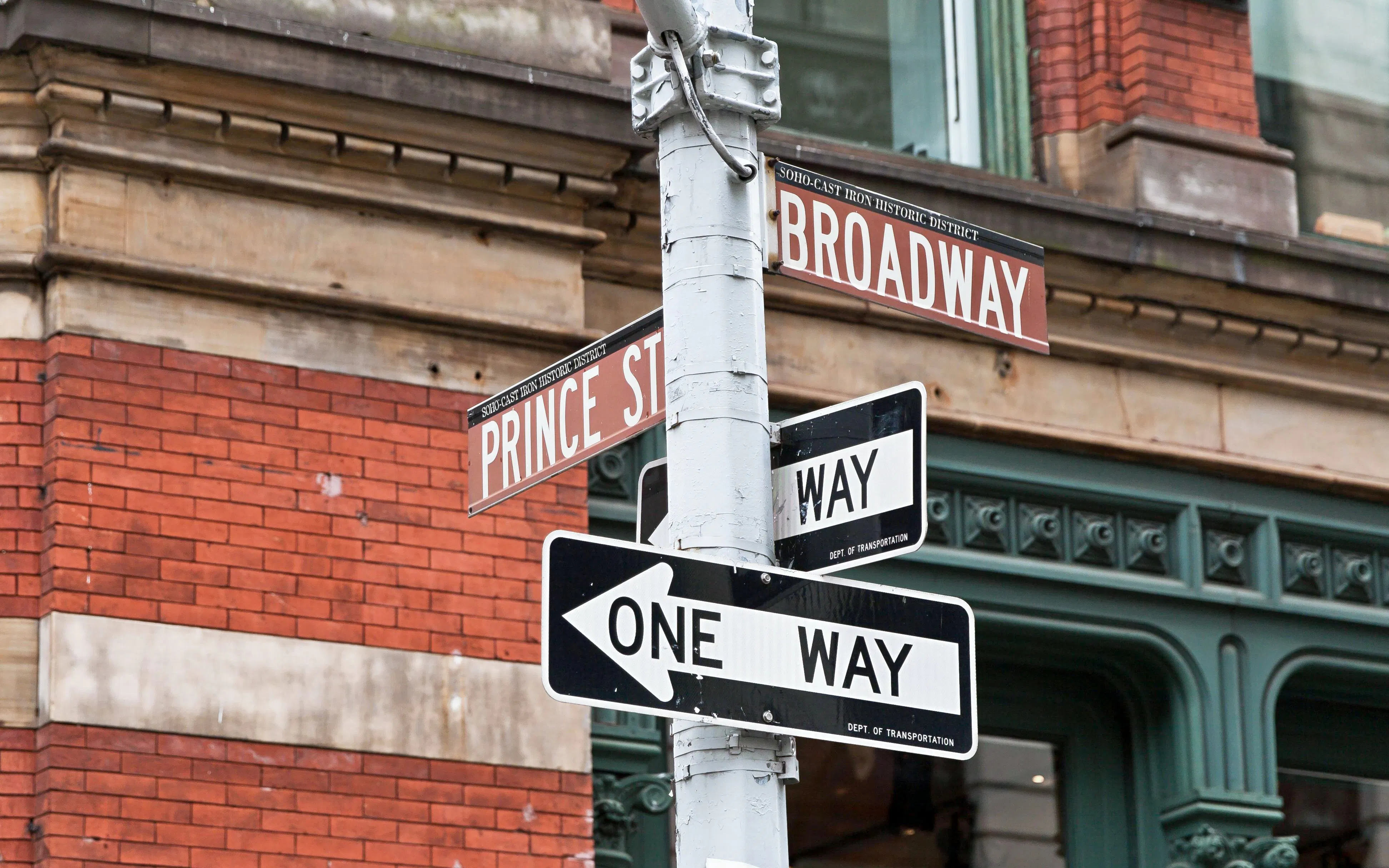 Street signs at Prince St and Broadway intersection in SoHo, New York City.