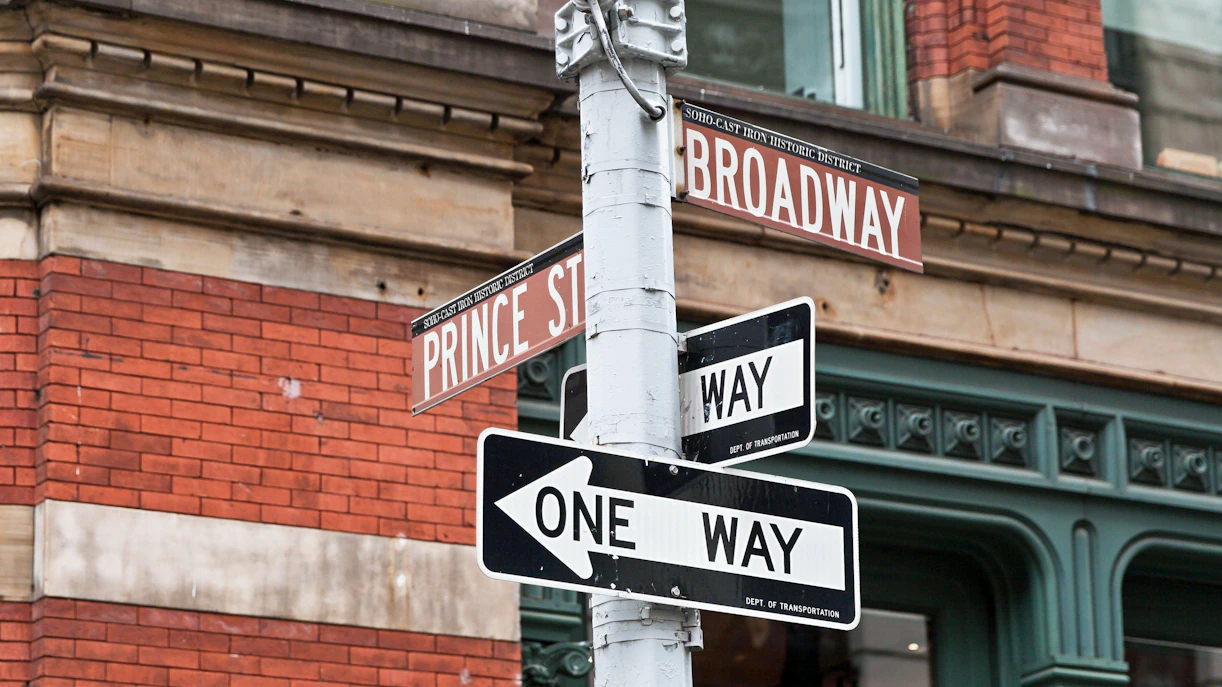 Street signs at Prince St and Broadway intersection in SoHo, New York City.