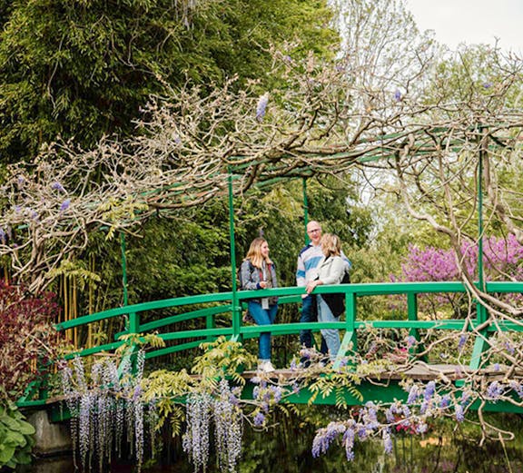 Visitors on a green bridge in Monet's Garden, Giverny, France.