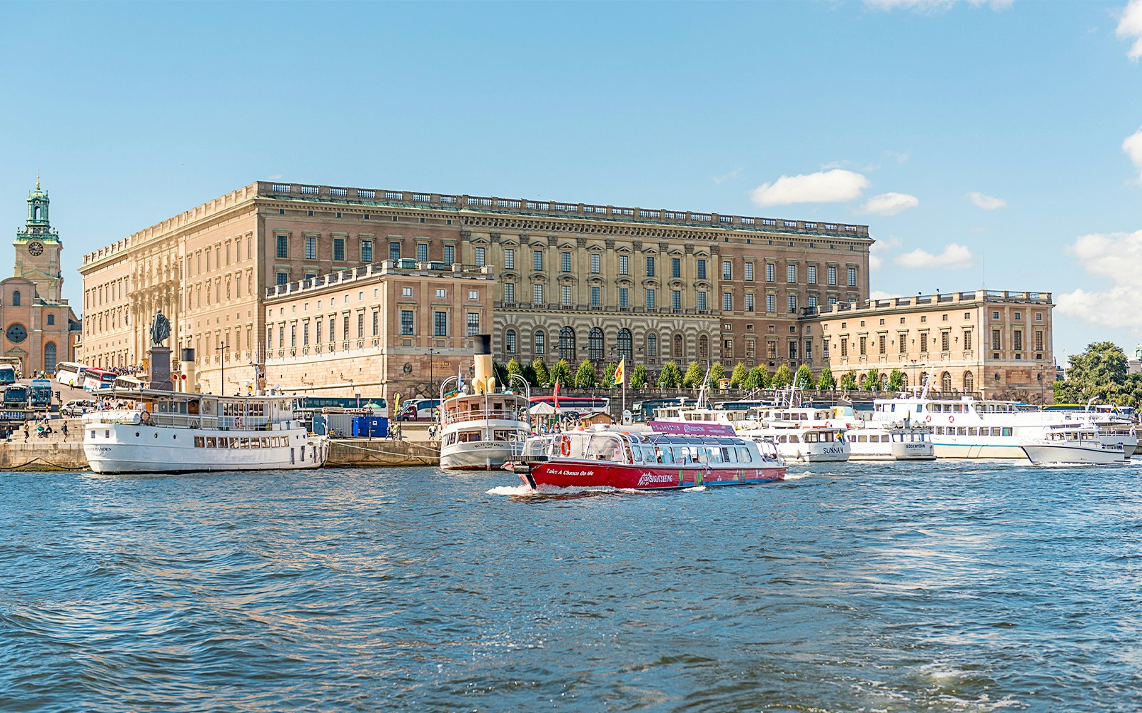 Tourists enjoying a Stockholm boat HOHO tour with a scenic view of the city's waterfront architecture