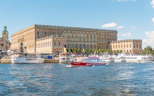 Stockholm hop-on hop-off boat near the Royal Palace on a sunny day.