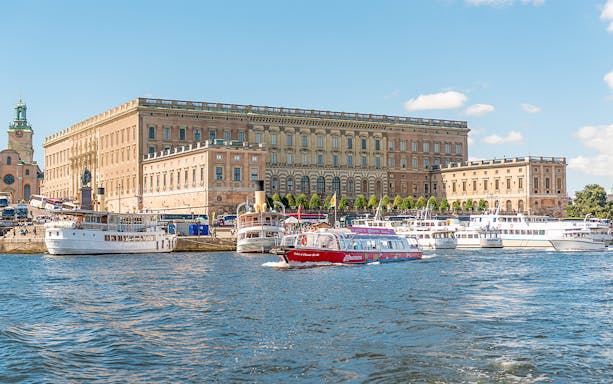Stockholm hop-on hop-off boat near the Royal Palace on a sunny day.