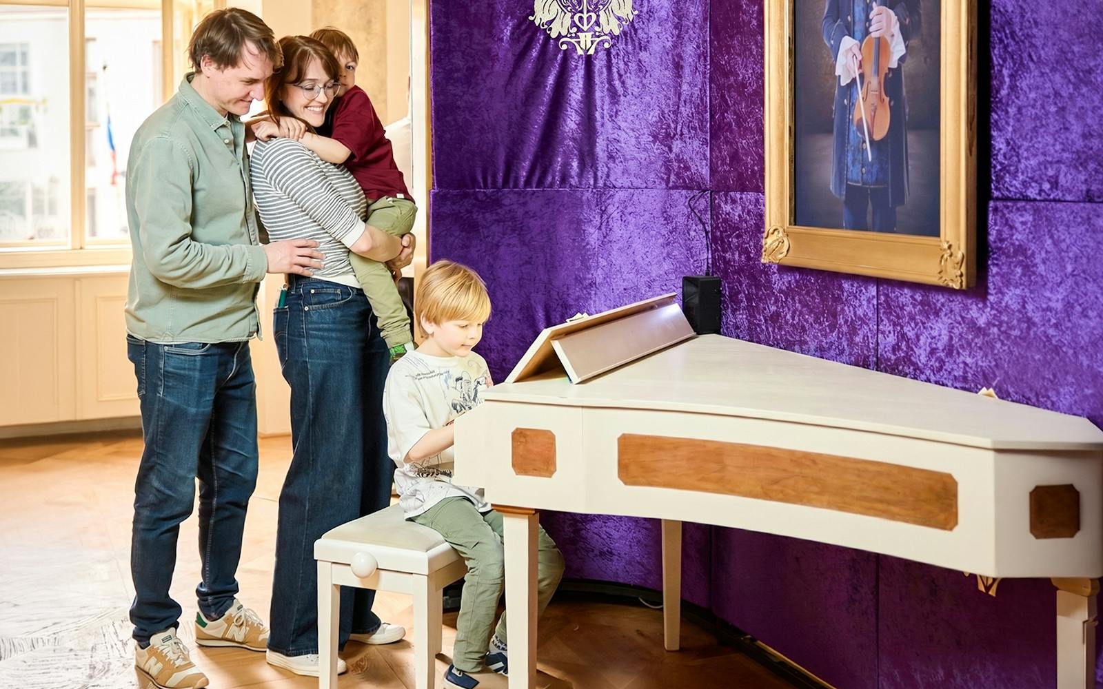 Family enjoying interactive piano exhibit at Prague Mozart Interactive Museum.
