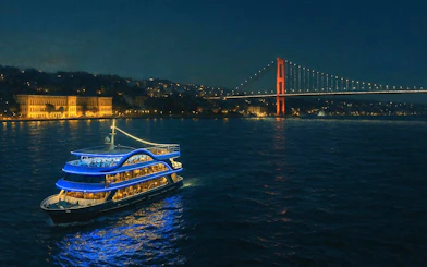 Luxury dinner cruise on the Bosphorus with illuminated bridge and cityscape in Istanbul.