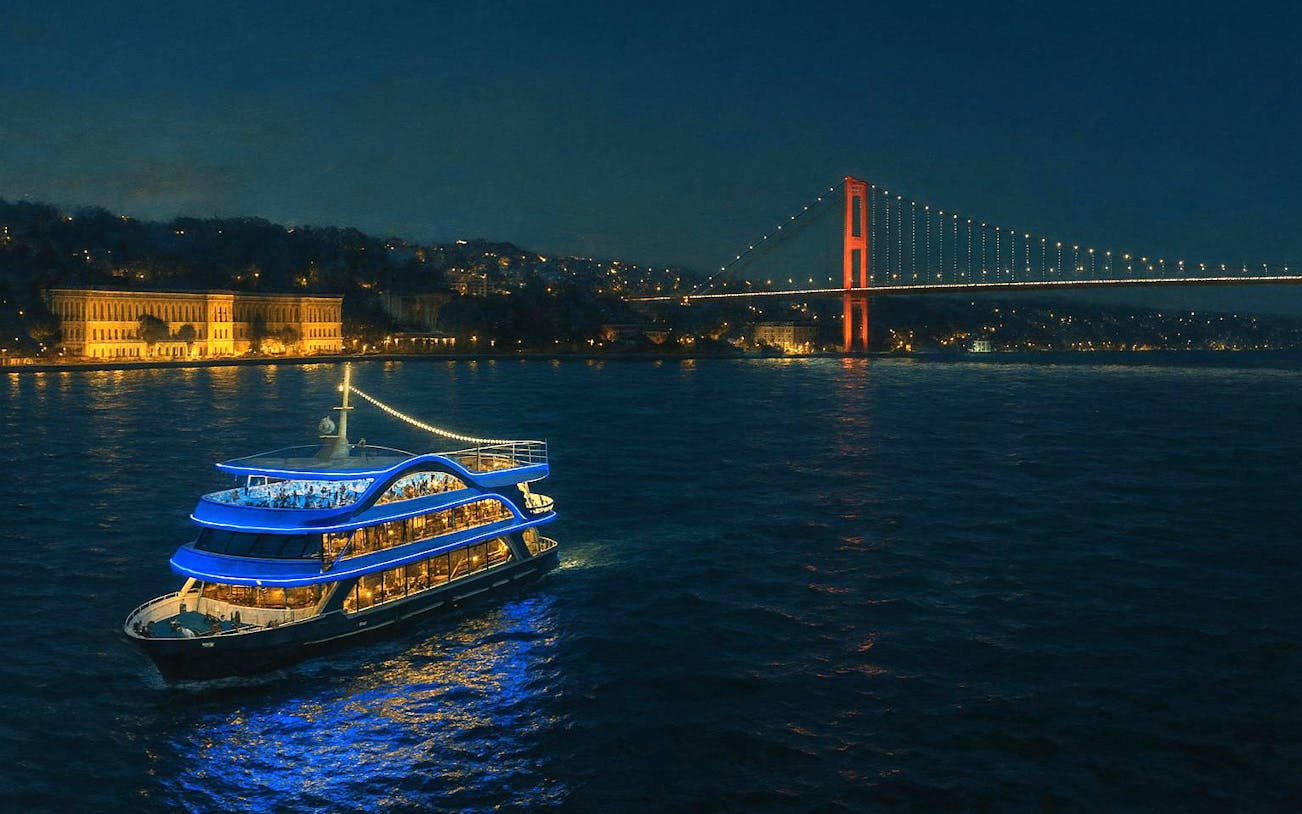 Luxury dinner cruise on the Bosphorus with illuminated bridge and cityscape in Istanbul.