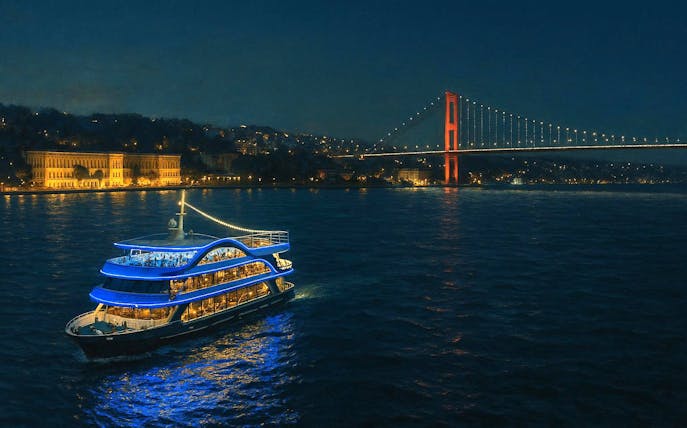 Luxury dinner cruise on the Bosphorus with illuminated bridge and cityscape in Istanbul.