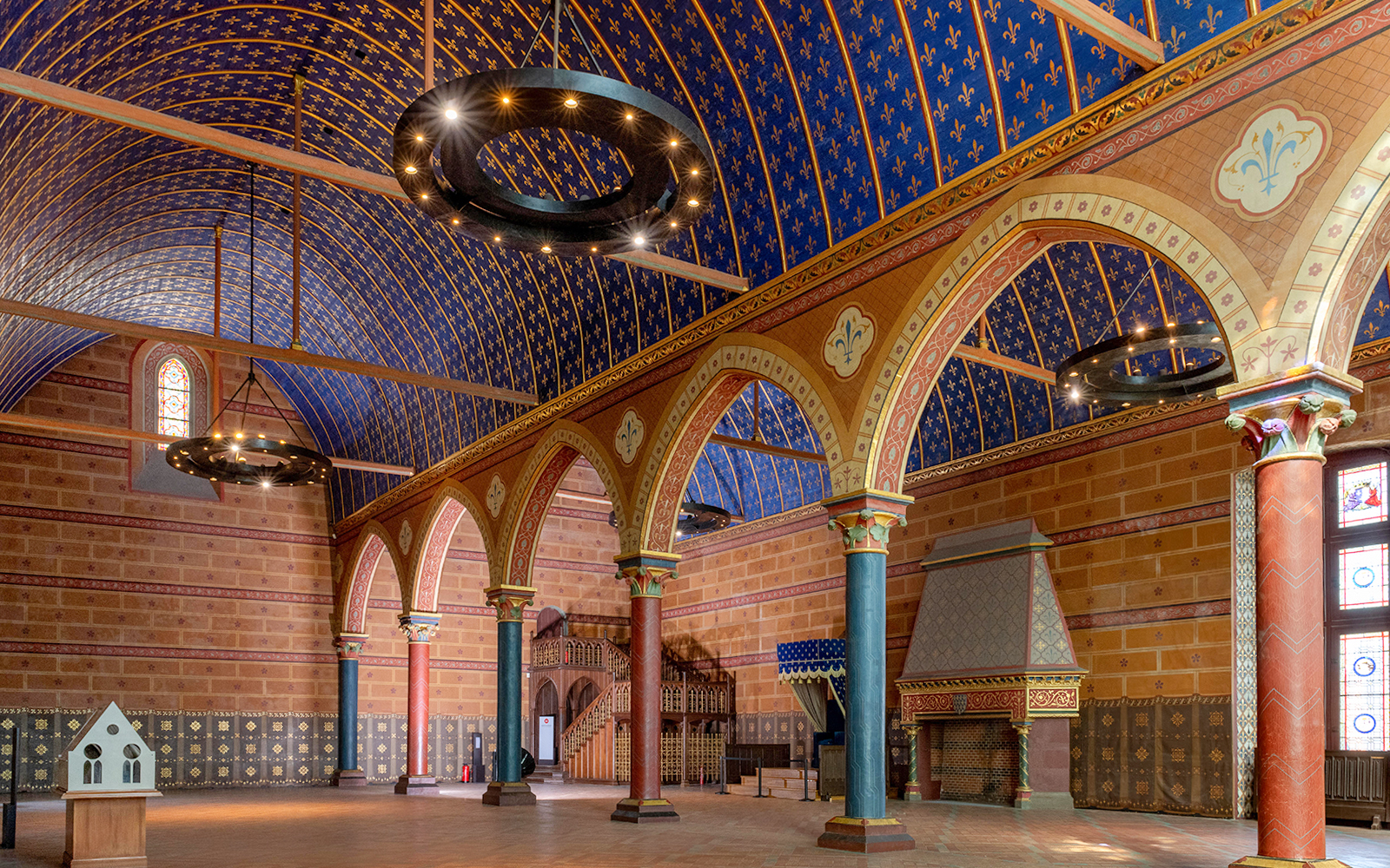 Interior of Royal Blois Castle with ornate arches and blue vaulted ceiling.