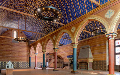 Interior of Royal Blois Castle with ornate arches and blue vaulted ceiling.