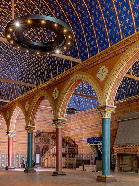 Interior of Royal Blois Castle with ornate arches and blue vaulted ceiling.