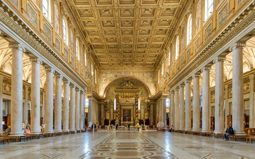 Interior of a Roman basilica with ornate ceiling and columns on the Appian Way tour.