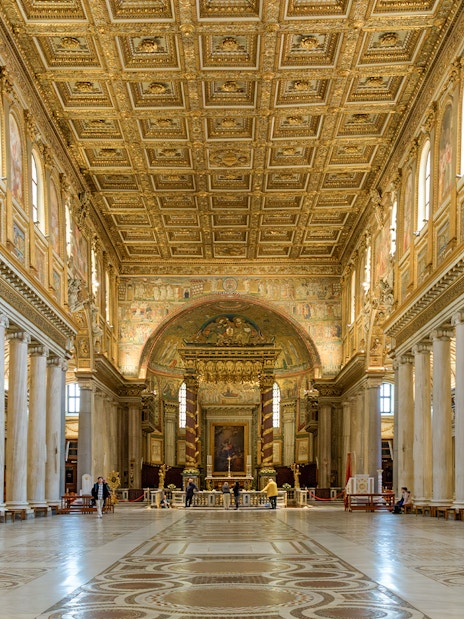 Interior of a Roman basilica with ornate ceiling and columns on the Appian Way tour.