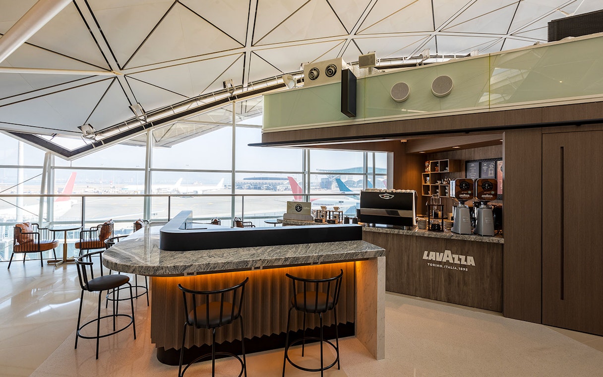 Plaza Premium Lounge coffee bar with airport runway view.