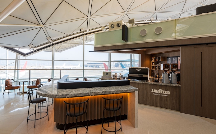 Plaza Premium Lounge coffee bar with airport runway view.