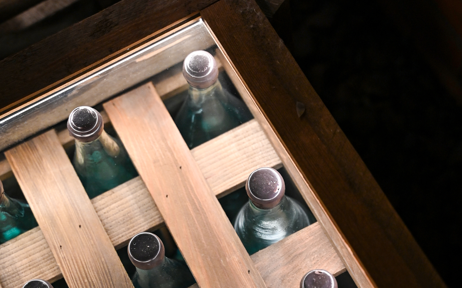 Bottles displayed in a wooden crate at a vodka factory in Krakow museum.