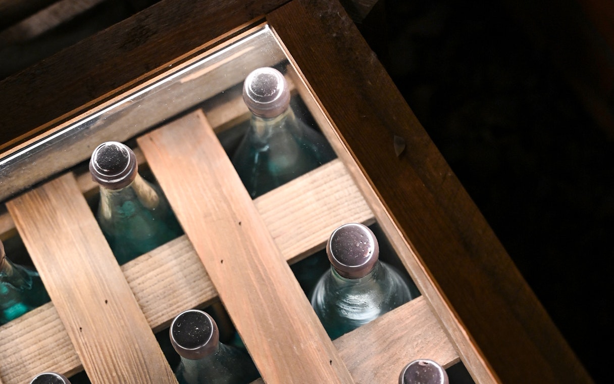 Bottles displayed in a wooden crate at a vodka factory in Krakow museum.