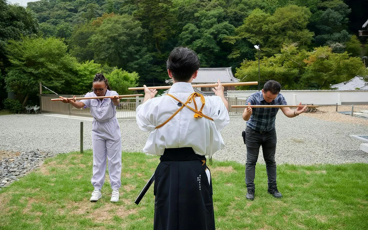Tourists practicing samurai sword techniques at Osaka temple training experience.