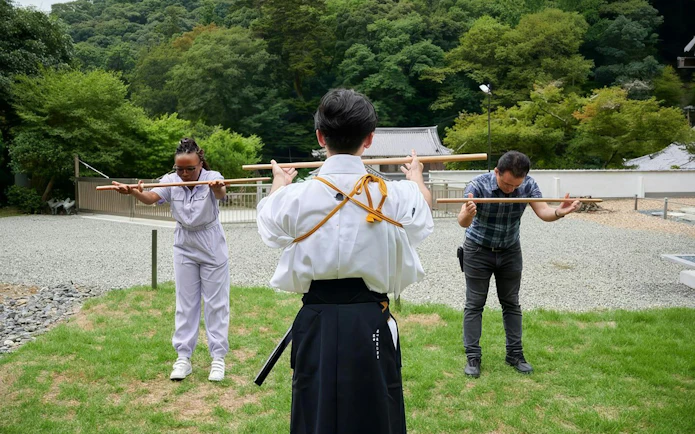 Tourists practicing samurai sword techniques at Osaka temple training experience.