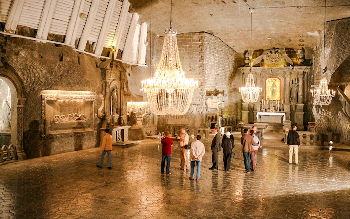 Visitors exploring the ornate chapel inside Wieliczka Salt Mine on a guided tour.
