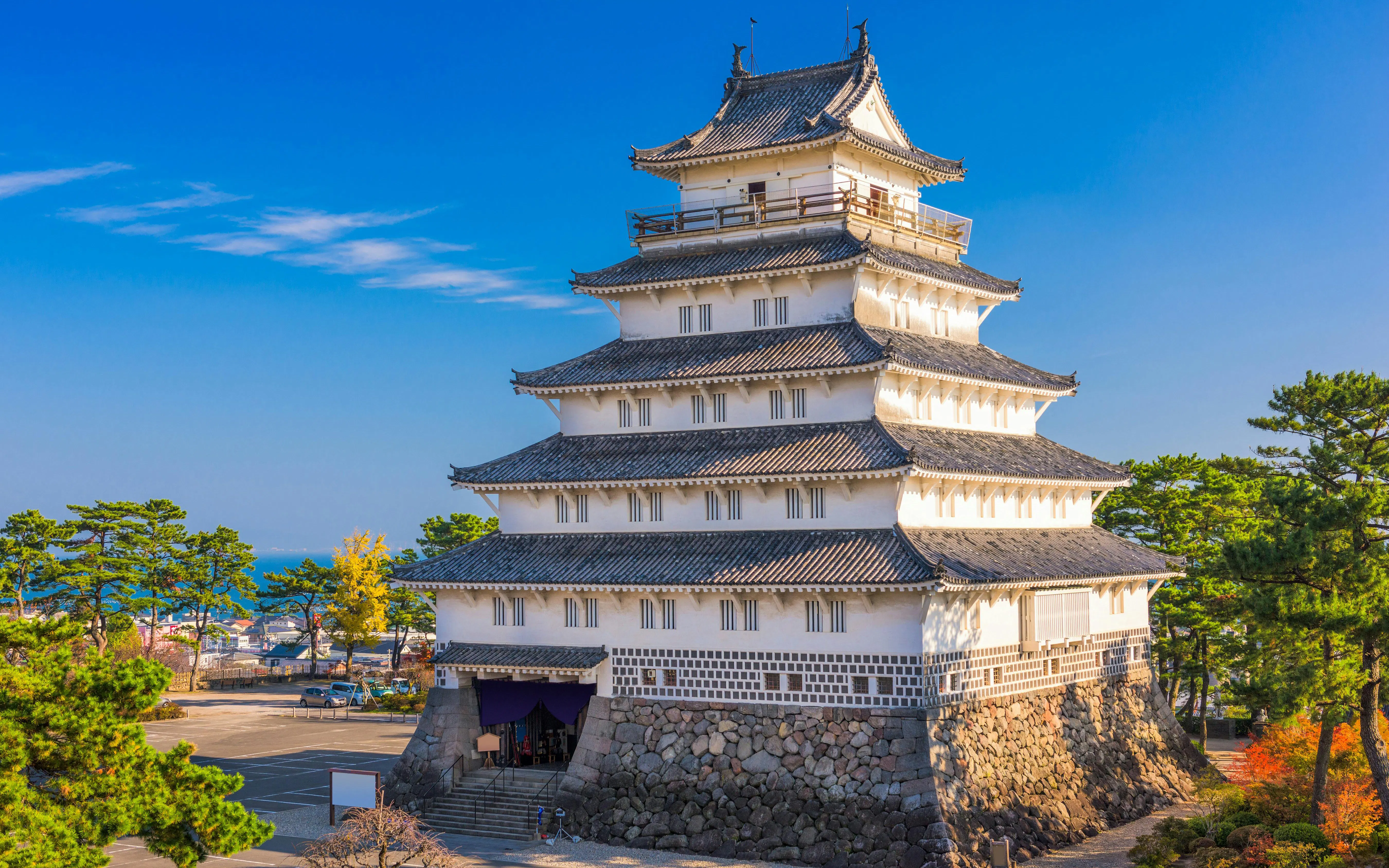 Shimabara Castle in Japan with traditional architecture and surrounding greenery.
