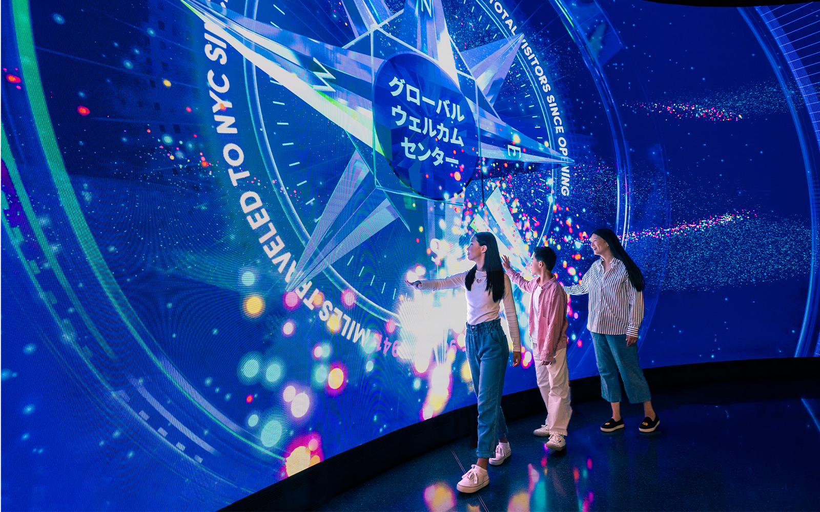 Tourists interacting with digital display at One World Observatory, New York City.