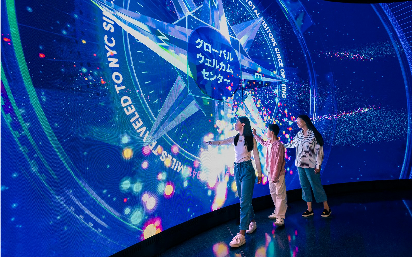 Tourists interacting with digital display at One World Observatory, New York City.
