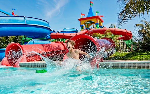Child splashing in water at Gardaland's Legoland Jungle Adventures, Verona.