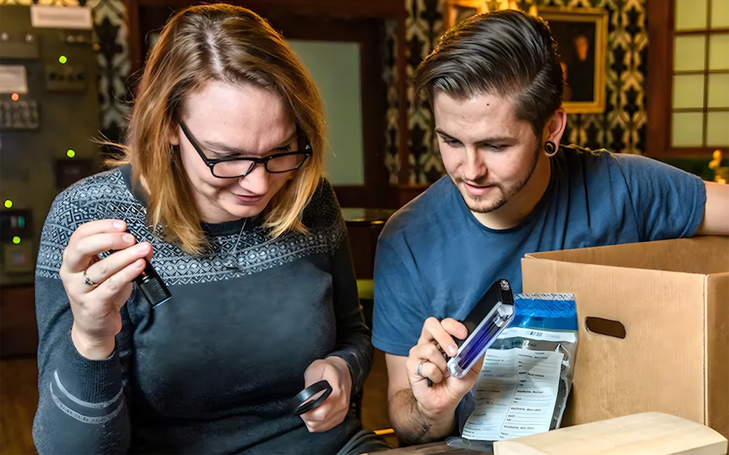 Participants solving clues in a Sherlock Holmes-themed escape room experience.
