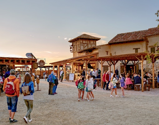 Visitors exploring historical reenactment at Puy du Fou España park, Toledo, Spain.