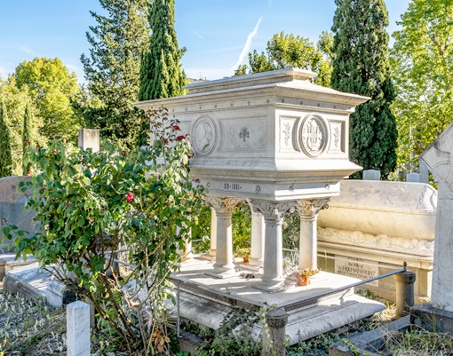 Grave of Elizabeth Barrett Browning in English Cemetery, Florence, surrounded by greenery.