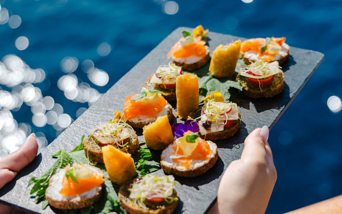 Assorted appetizers on a slate platter during Athens day cruise lunch.