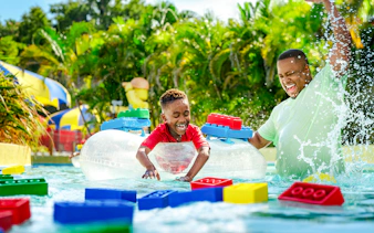 Child enjoying Lazy River at Legoland Florida Water Park with colorful Lego floats.