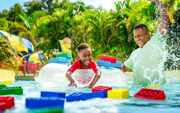 Child enjoying Lazy River at Legoland Florida Water Park with colorful Lego floats.