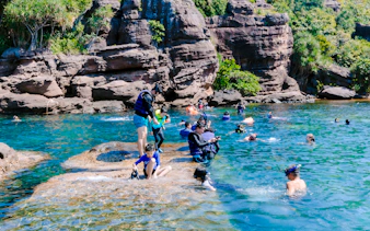Snorkelers exploring clear waters near rocky cliffs on Phu Quoc's 3 Island Hopping Tour.
