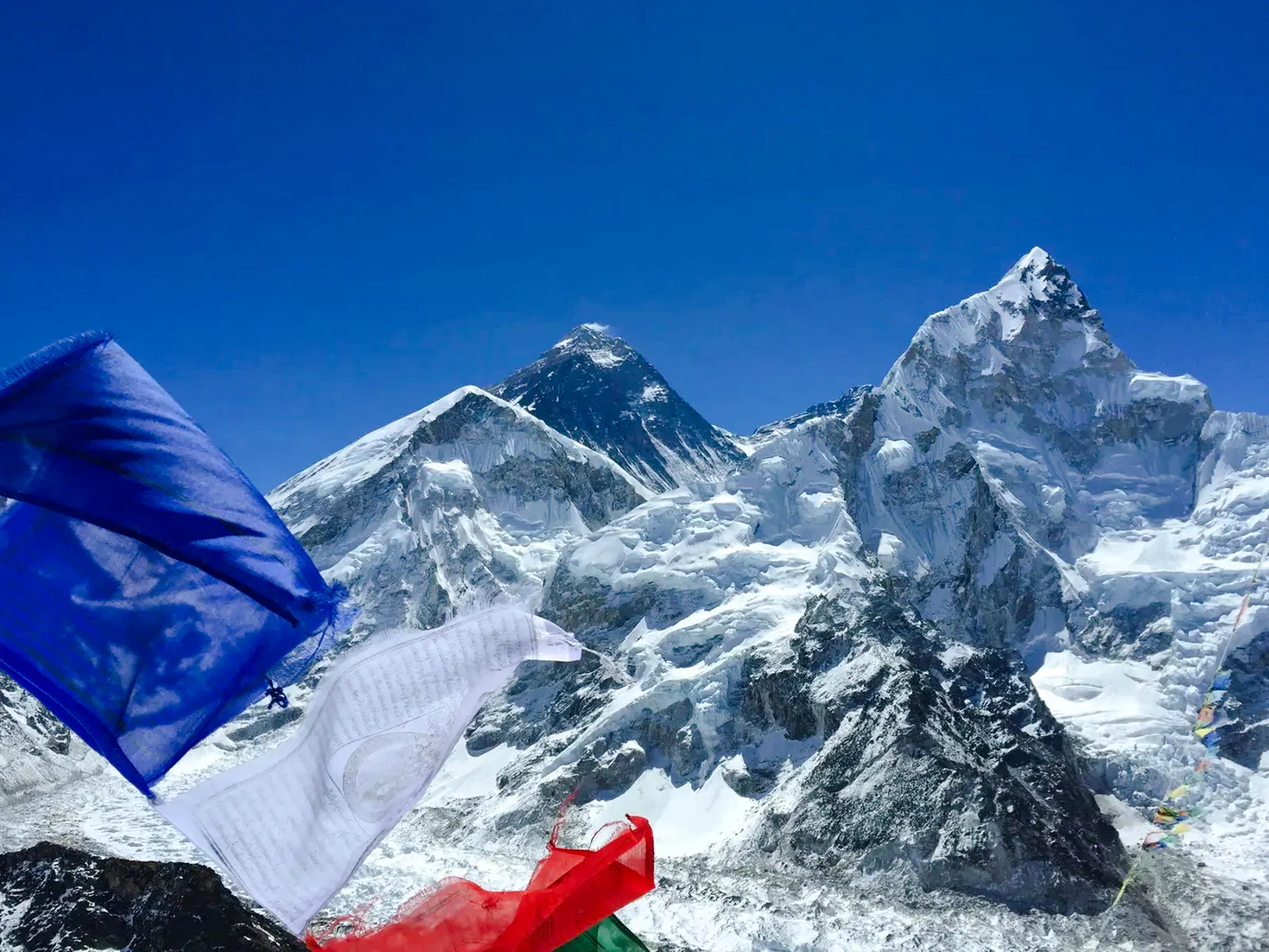 Prayer flags with Mount Everest in the background, Everest Region helicopter tour.