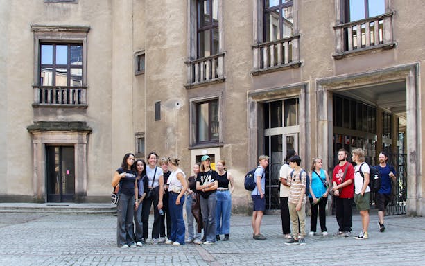 Group of tourists outside Nowa Huta Steel Mill Administration Buildings in Krakow.