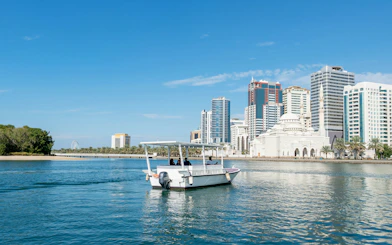 Boat tour on Khalid Lagoon with Sharjah skyline in the background.