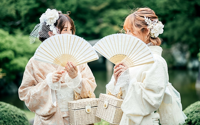 Individuals in traditional Japanese kimono holding fans during a rental experience.