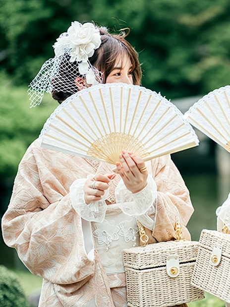 Individuals in traditional Japanese kimono holding fans during a rental experience.