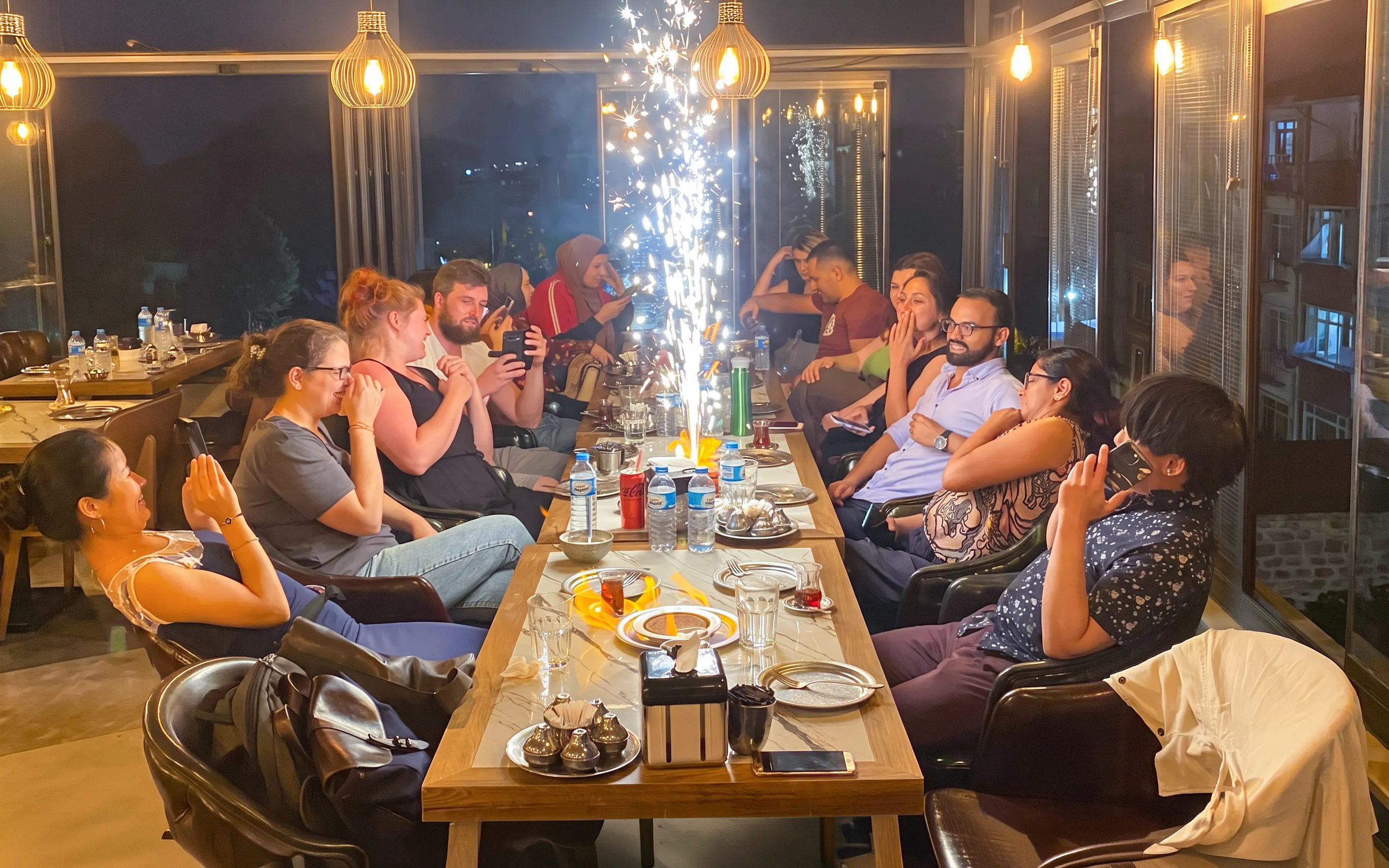 Guests dining at a Turkish Food Night event in Istanbul, seated around a table with sparklers.