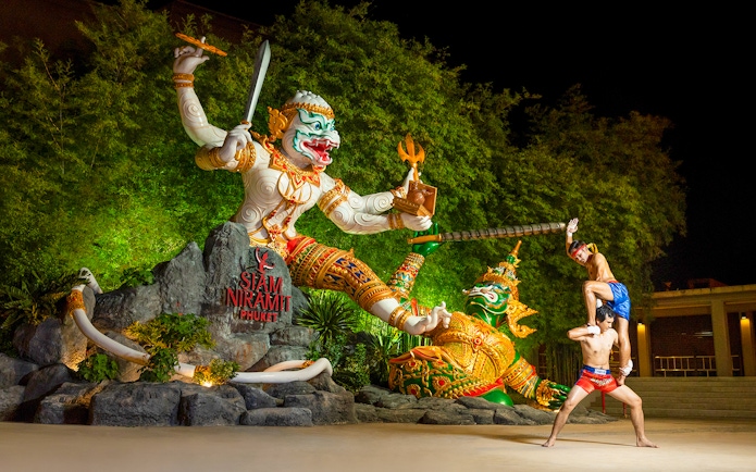 Thai boxers performing at Siam Niramit preshow in front of giant statues.