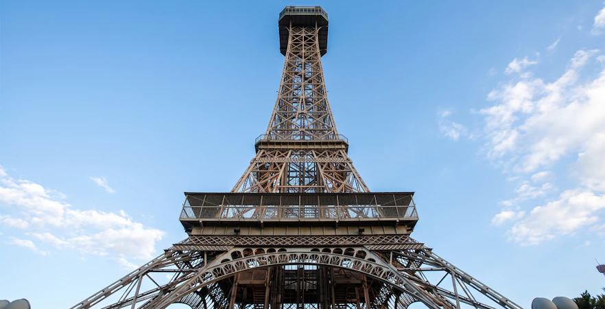 Eiffel Tower replica at King's Island, Six Flags against blue sky.
