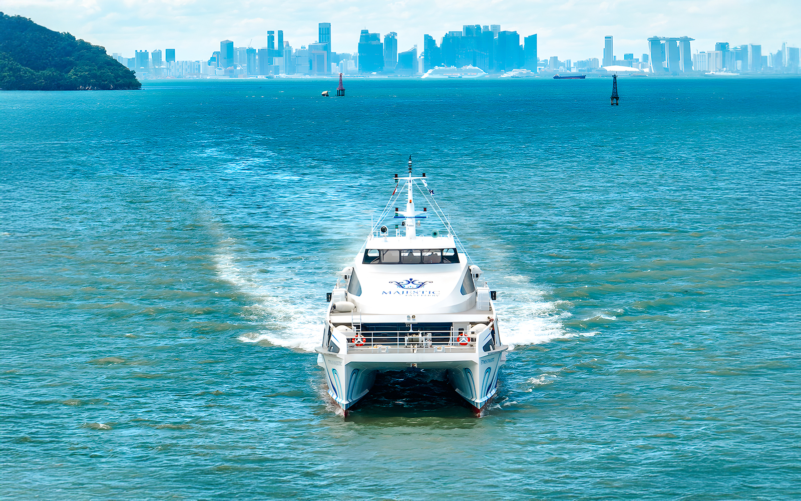 Ferry traveling from Singapore to Batam with city skyline in the background.