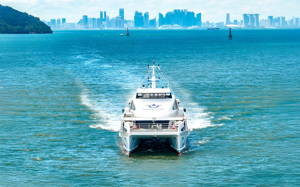 Ferry traveling from Singapore to Batam with city skyline in the background.