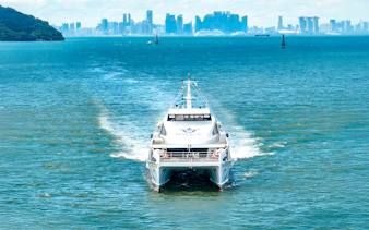 Ferry traveling from Singapore to Batam with city skyline in the background.