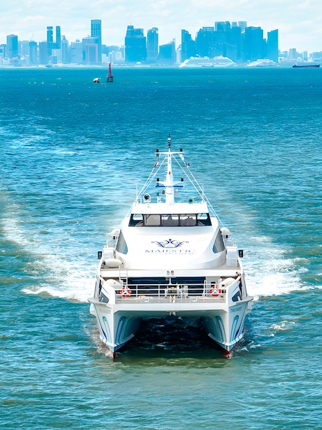 Ferry traveling from Singapore to Batam with city skyline in the background.