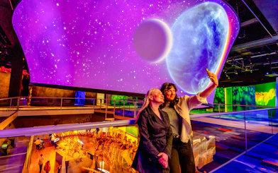 Visitors taking a selfie at the Our Wondrous Planet exhibit in Melbourne Museum.