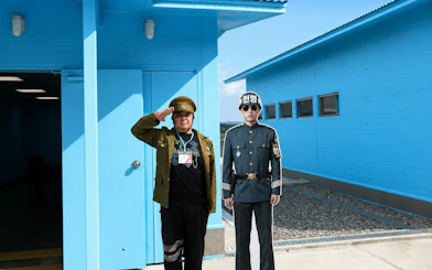 Person saluting beside a soldier cutout at DMZ JSA Photo Zone, South Korea.